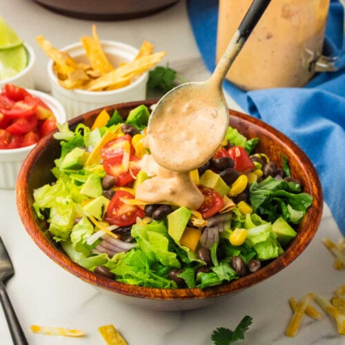 Creamy Chipotle Sauce & Dressing being spooned on a salad.
