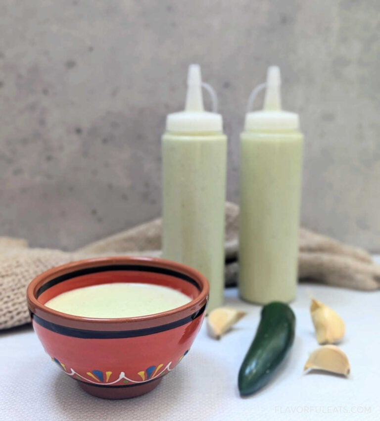 Creamy Serrano Garlic Sauce in a small bowl and in squeeze bottles.
