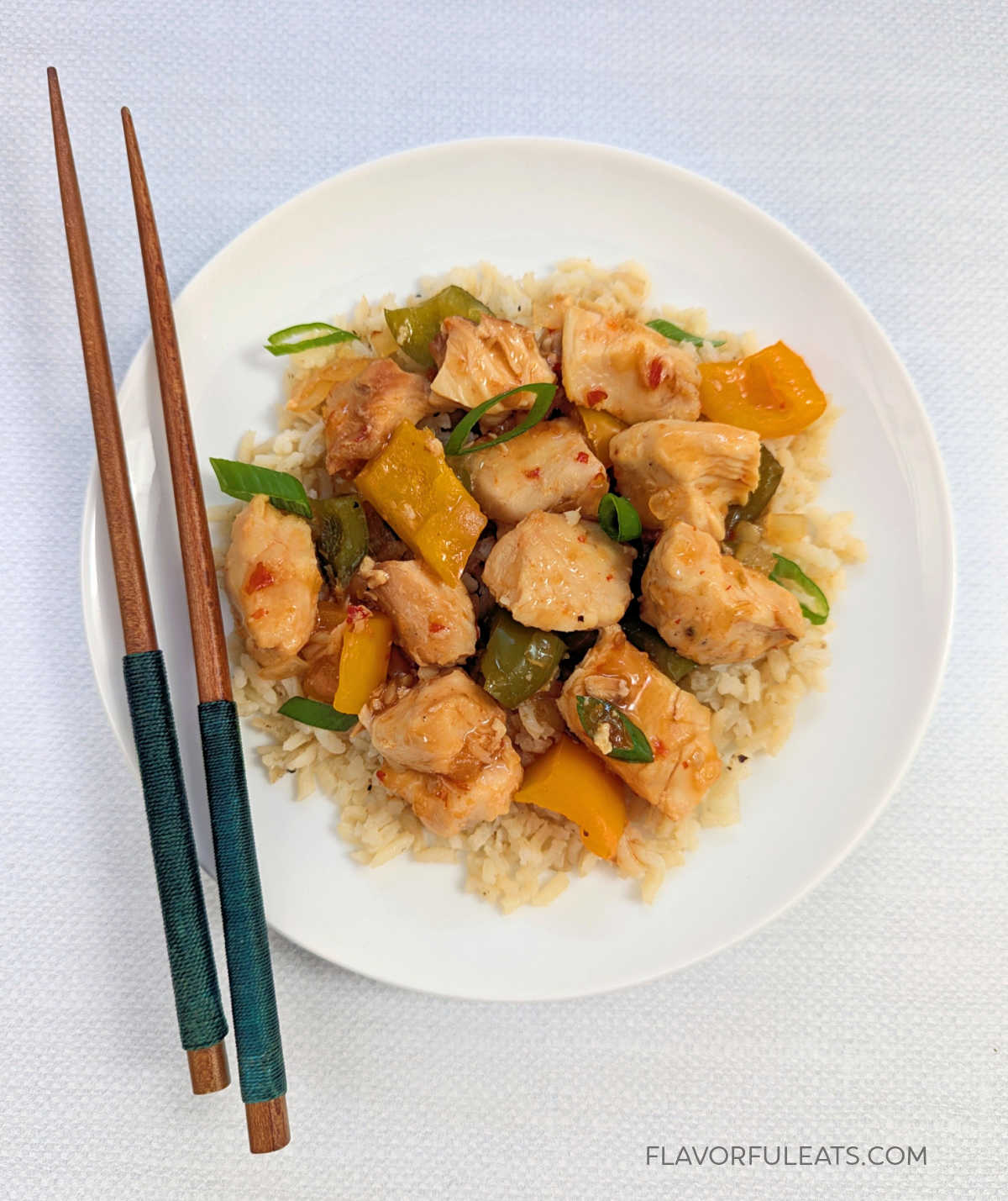 Slow Cooker Sweet Chili Chicken plated with chopsticks.